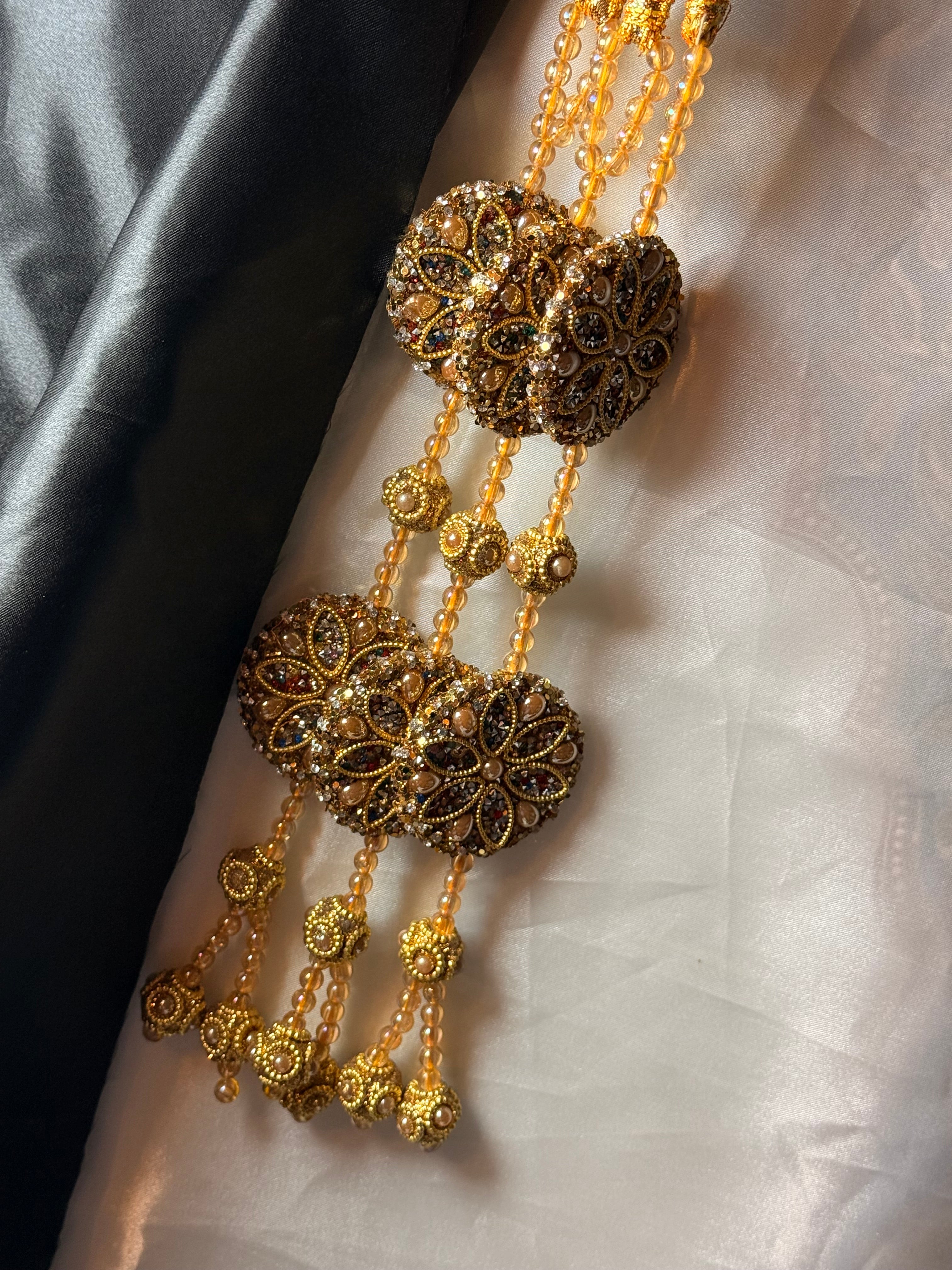 Gold bracelet with intricate designs on a textured white surface