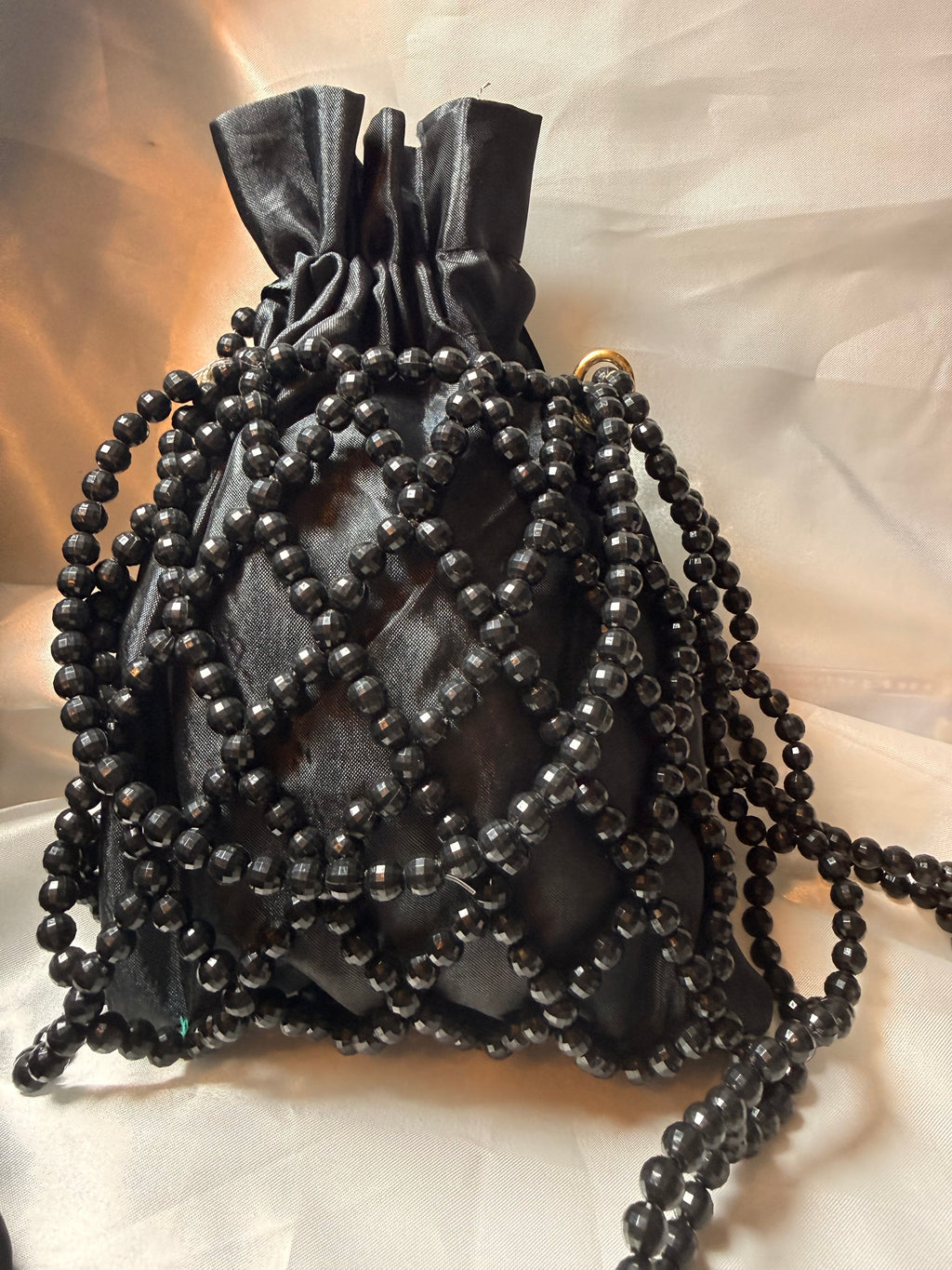 Black beaded handbag on a light background