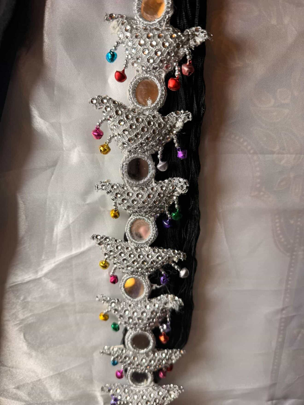 Decorative hair accessory with stars and colorful beads on a white fabric background
