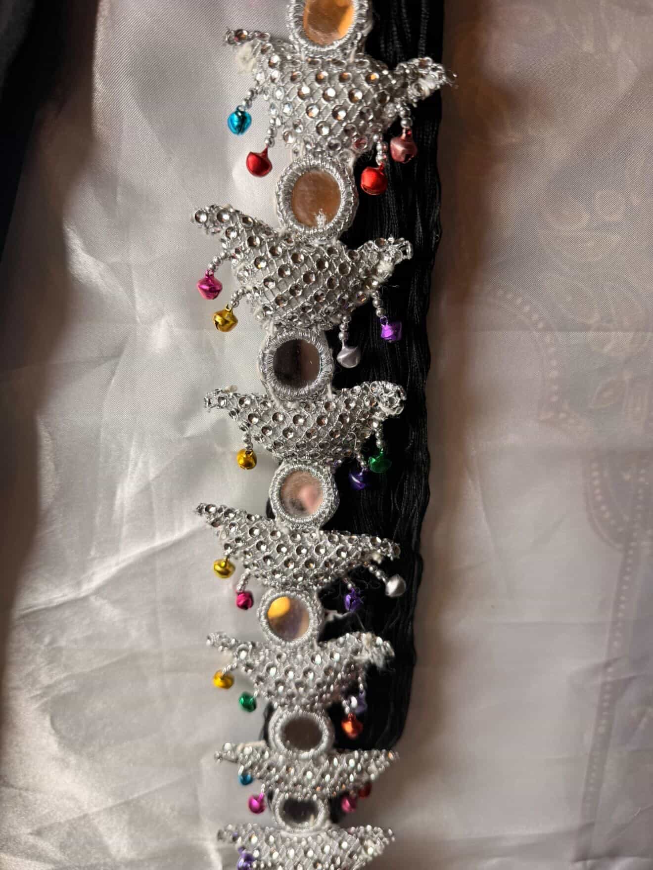 Decorative hair accessory with stars and colorful beads on a white fabric background
