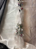 Decorative hanging with tassels and beads on a textured white background