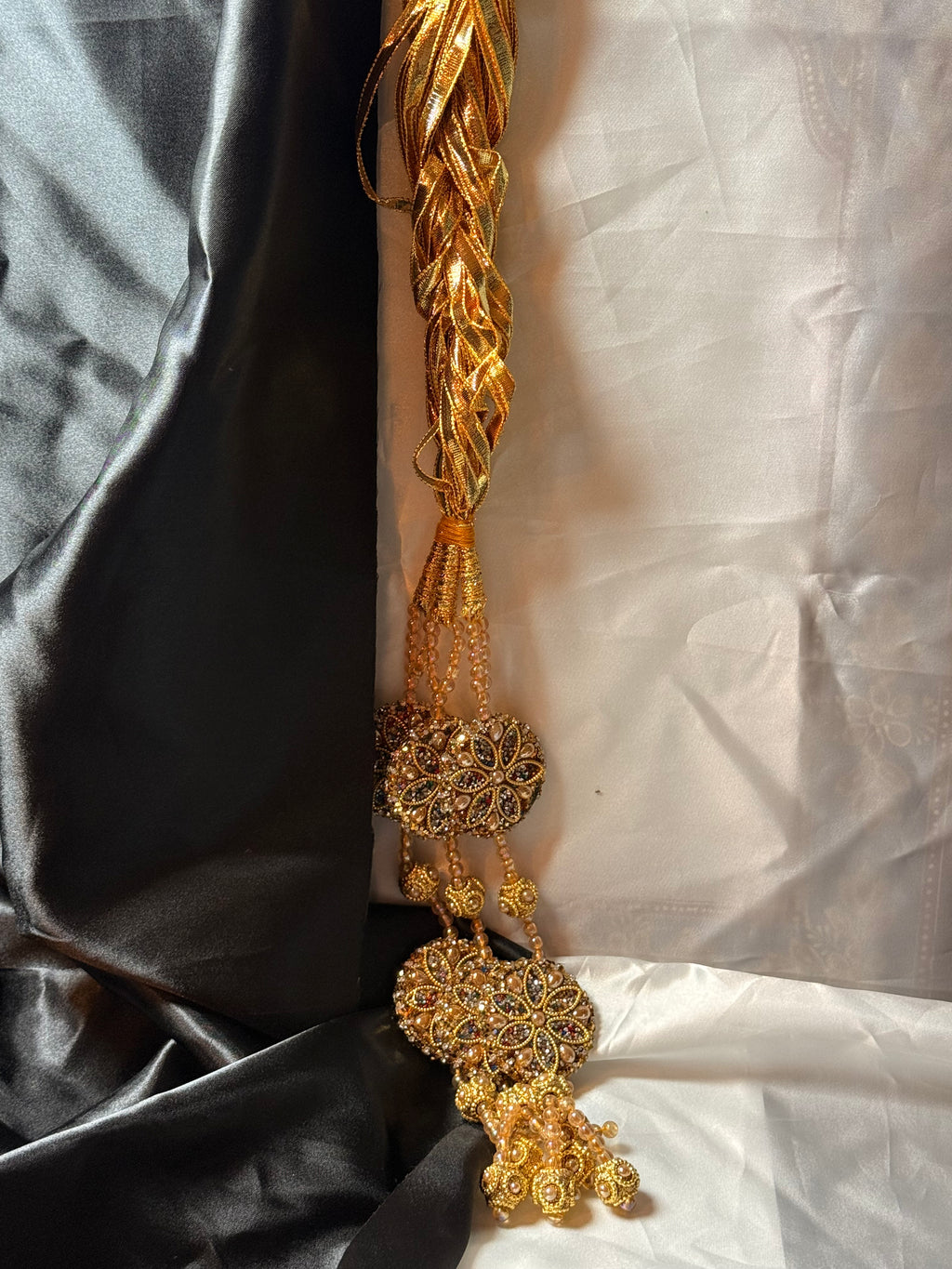 Decorative gold belt with intricate designs on a black and white fabric background