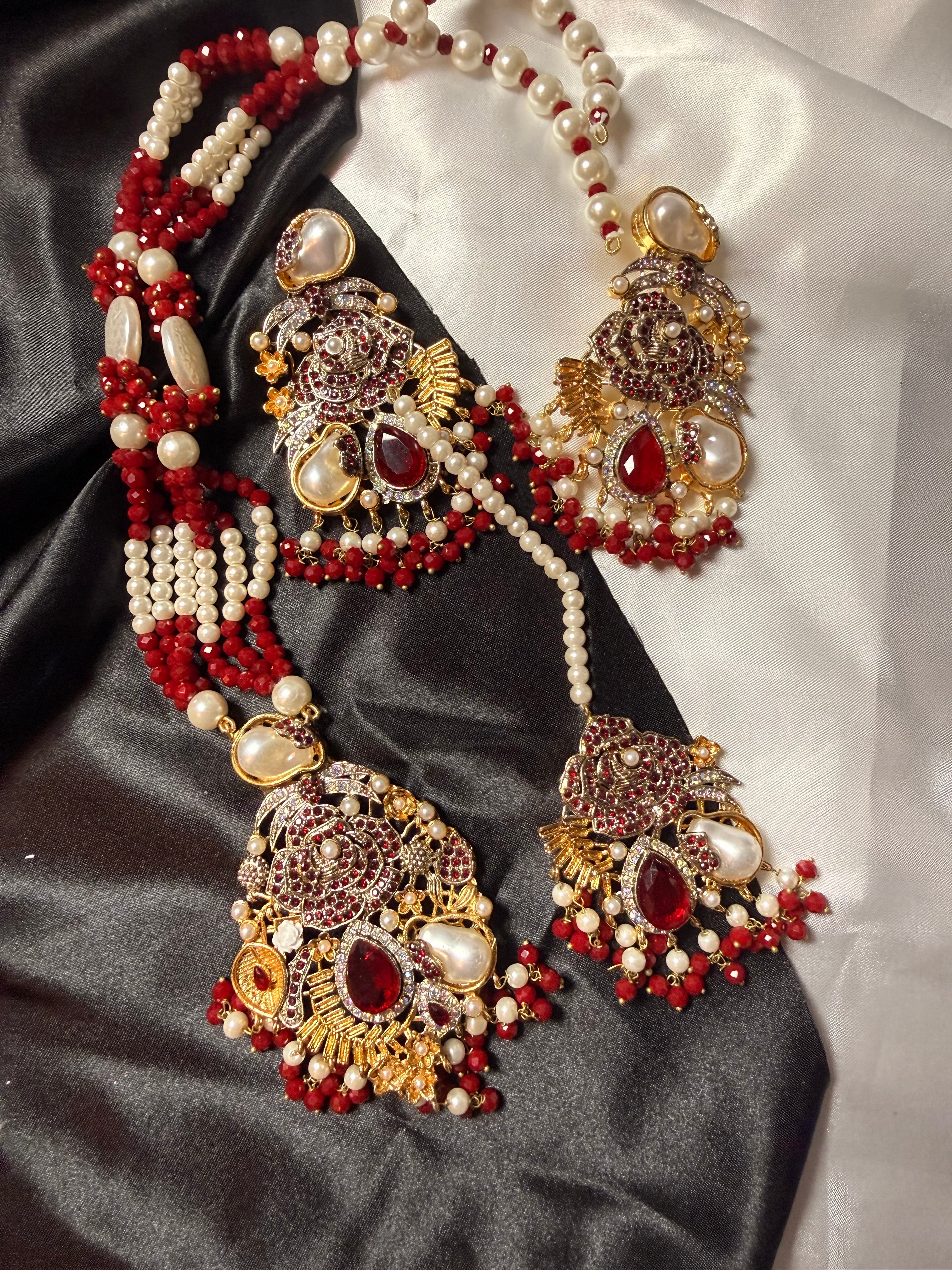 Ornate necklace with red and gold beads on a satin background