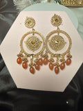 Gold and brown jewelry set on a pink hexagonal card