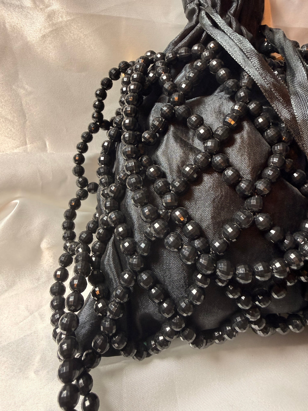 Black beaded clutch bag on a light gray background