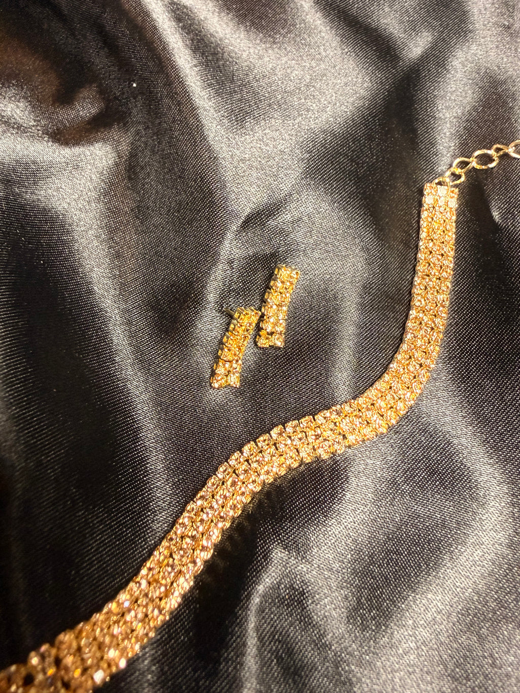 Gold necklace on a black satin surface