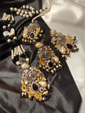 Ornate jewelry set with pearls on a black satin background