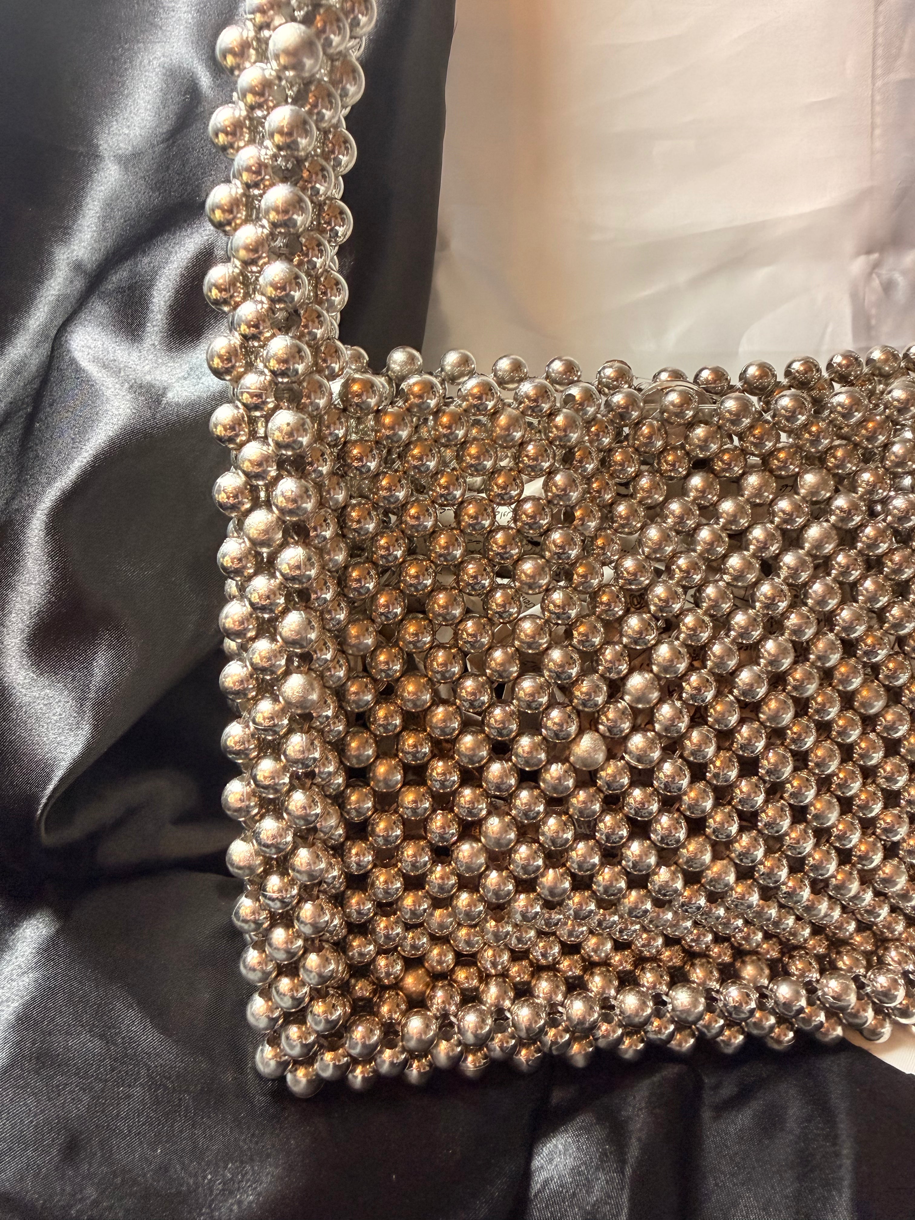 Close-up of a beaded clutch bag on a black satin surface