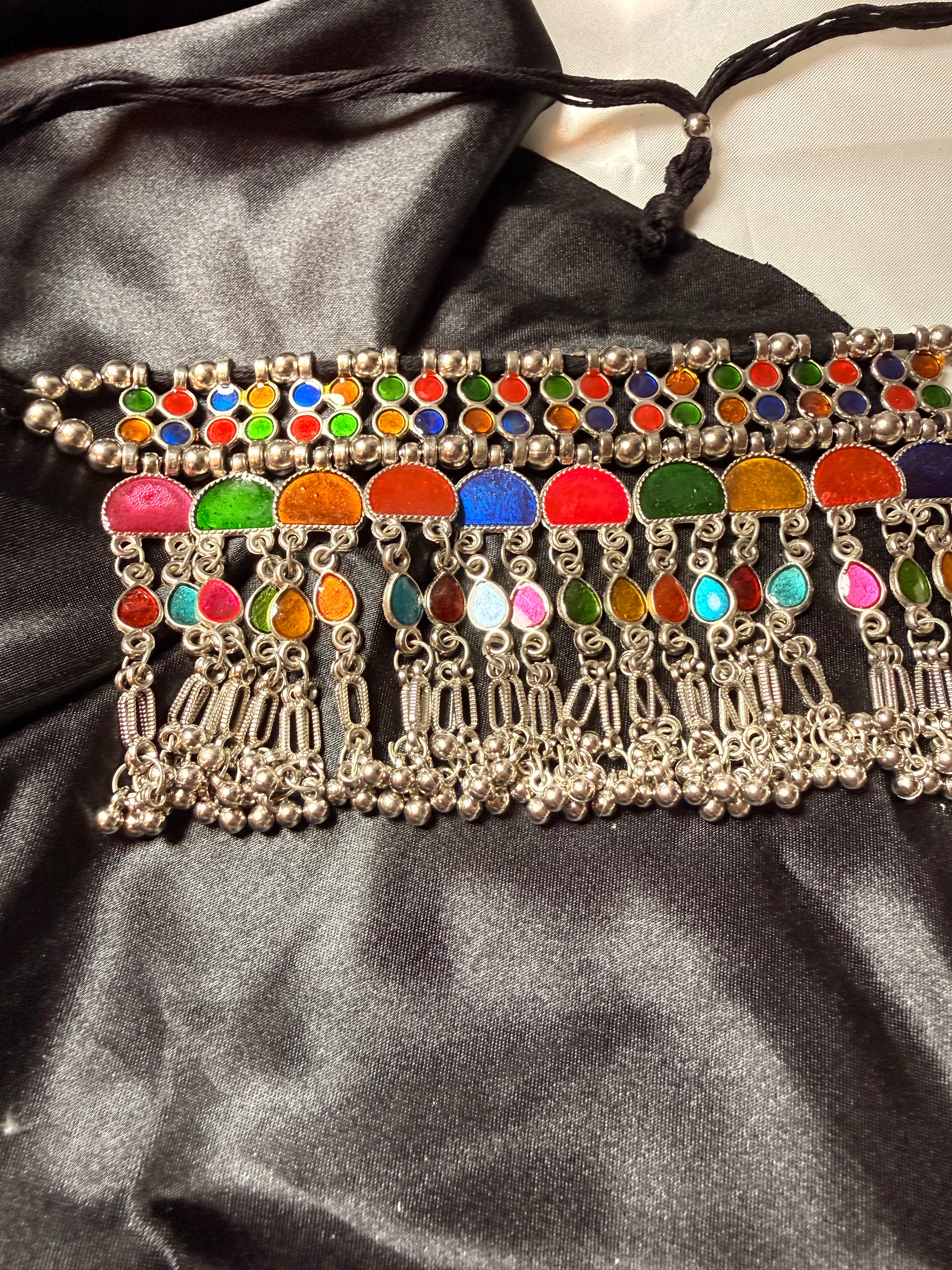 Decorative belt with colorful beads and silver accents on a black satin background