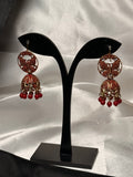 Decorative earrings on a black stand with a white background