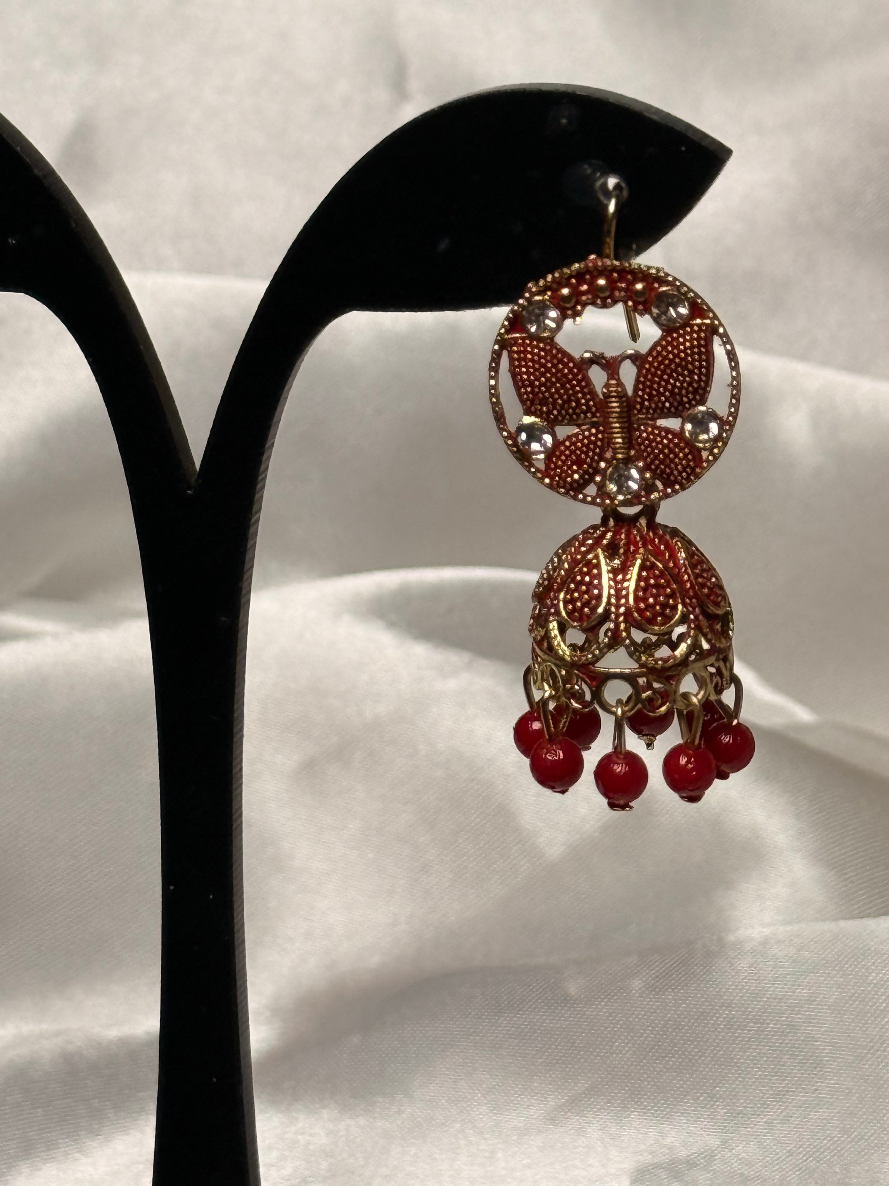 Decorative earring with red beads on a white background